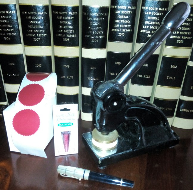 notarial embosser and seals with lawbooks background